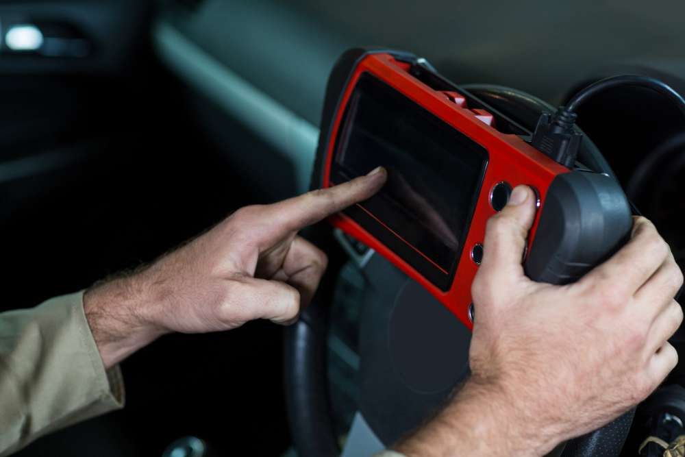 Automotive locksmith technician using diagnostic key programming device in Phoenix AZ