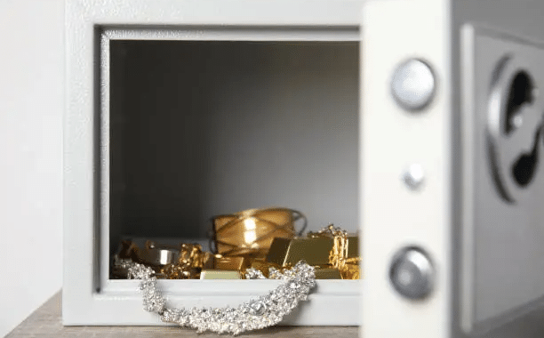 An open steel safe with jewelry in it